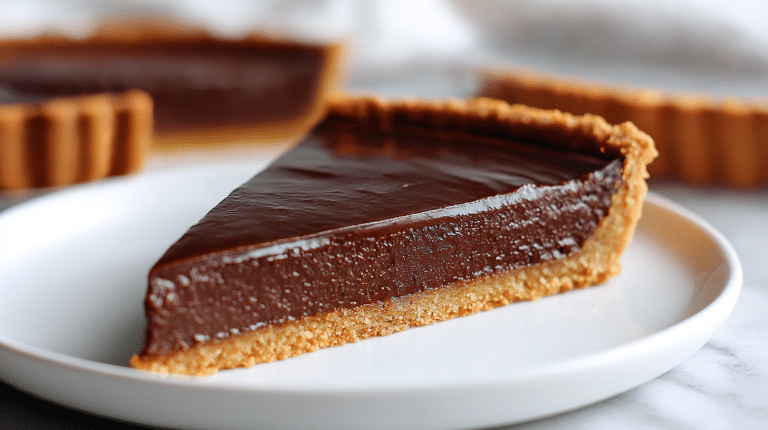 A close-up of gordon ramsay chocolate tart showcasing its glossy ganache.
